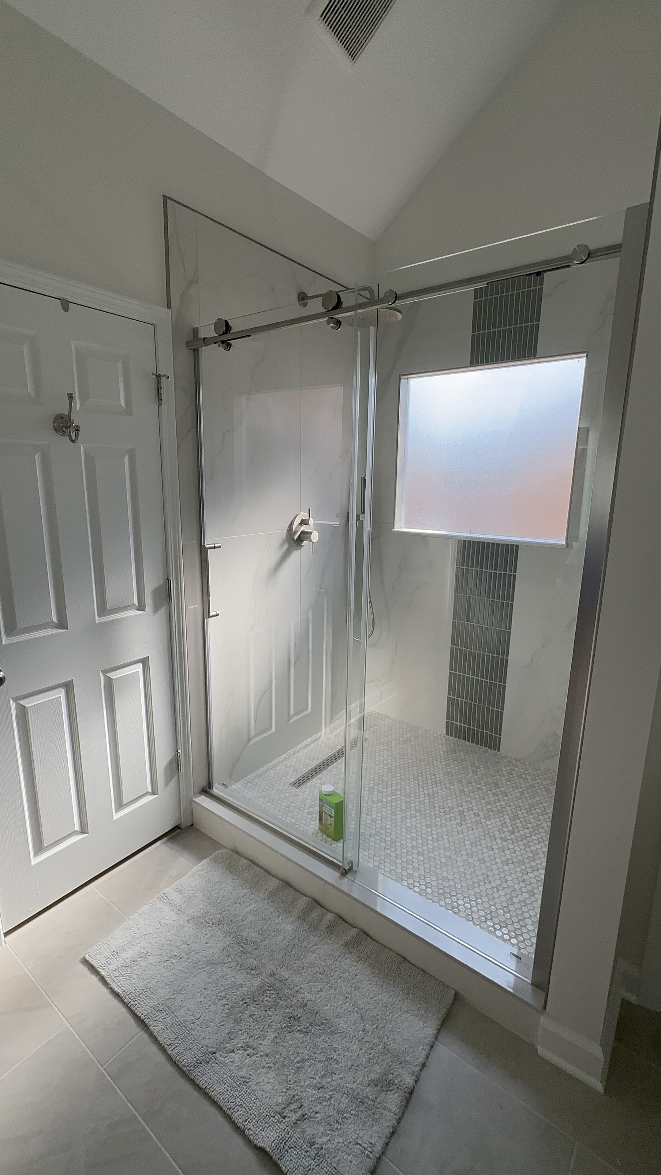 Modern glass shower enclosure with marble tile